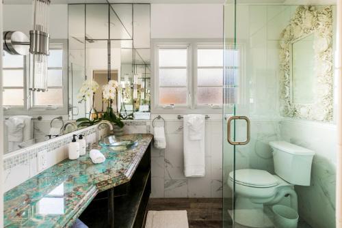Un baño con lavabo, inodoro y espejo. en New Listing The Nautilus Manhattan Beachfront Retreat, en Manhattan Beach