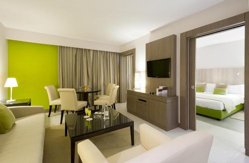 une chambre d'hôtel avec un lit et un salon dans l'établissement Golf Royal Hotel, à Tunis
