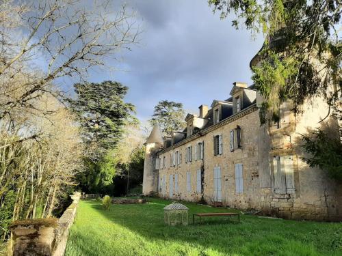 a large stone building with a grassy yard in front of it at Chambre au Château in Le Vigan