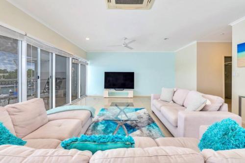 a living room with two couches and a tv at Marina View Sunset Magic in Larrakeyah