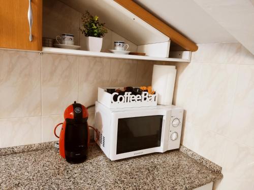 a microwave sitting on top of a counter at Buen Camino Arzua in Arzúa