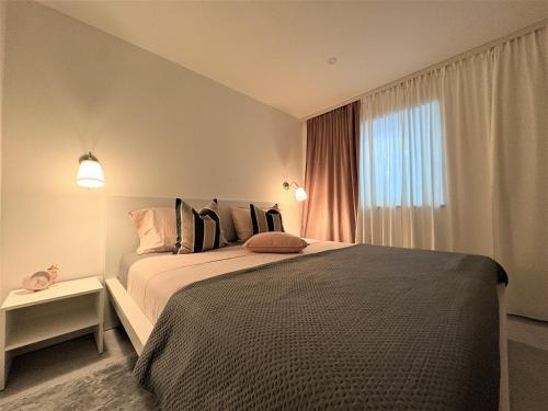 Un dormitorio con una cama grande con ventana. en Tina's Sunset Haven, en Ustrine