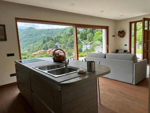 a kitchen with a sink and a large window at Bellagio Lake View apartment Rosabella with swimming-pool in Civenna