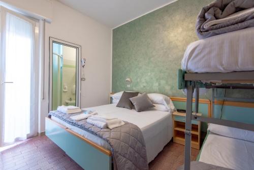 a bedroom with two bunk beds and a window at Hotel Baltic in Gabicce Mare