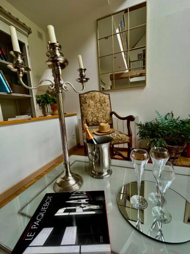 une table en verre avec une lampe et des verres dessus dans l'établissement Clos Almahe, à Gainneville