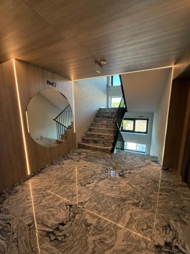an empty room with a staircase and a mirror at Maison Apartment - NEO TOWER in Suceava