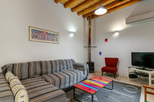 a living room with a couch and a tv at Annis House in Kato Lefkara