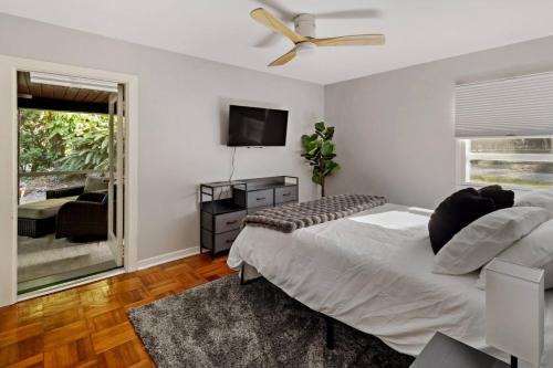 Un dormitorio con una cama y un televisor de pantalla plana. en 1920s Speakeasy, Horses Hot Tub 5mi to Beach, en Vero Beach