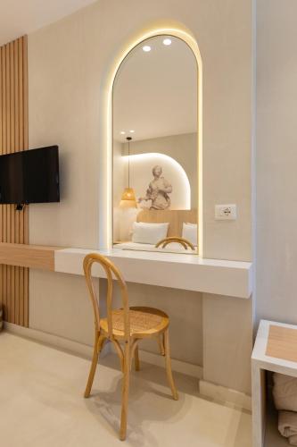 a chair in a room with a mirror at Dimitri Hotel in Himare