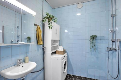 a bathroom with a washing machine and a sink at Red Bauhaus Kamppi Square 35m tram bus Wi-Fi in Helsinki