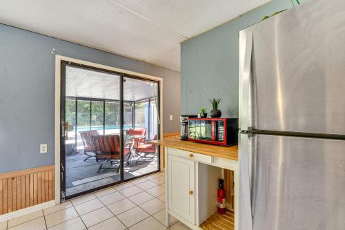 a kitchen with a stainless steel refrigerator and a patio at Old Florida Charm Homosassa Home with Lanai! in Homosassa