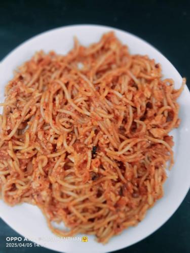 a white plate of noodles on a table at Trinco Chill Zone Hostel in Trincomalee