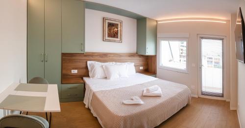 une chambre avec un lit avec deux serviettes blanches dessus dans l'établissement BnB Tirana Centro Balcony, à Tirana