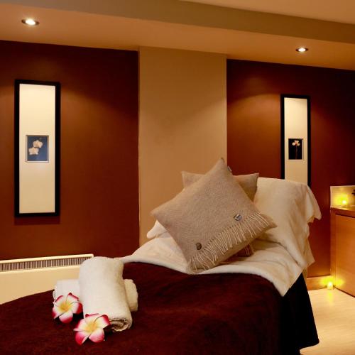 a bedroom with a bed with pillows and flowers on it at Macdonald Hill Valley Hotel, Spa & Golf Resort in Whitchurch