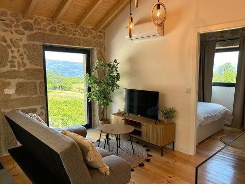 a living room with a couch and a tv at Casa Laurinha by Lethes Legacy in Ponte de Lima