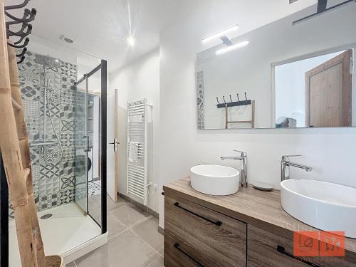 een badkamer met twee wastafels en een glazen douche bij La parenthèse in Wimereux