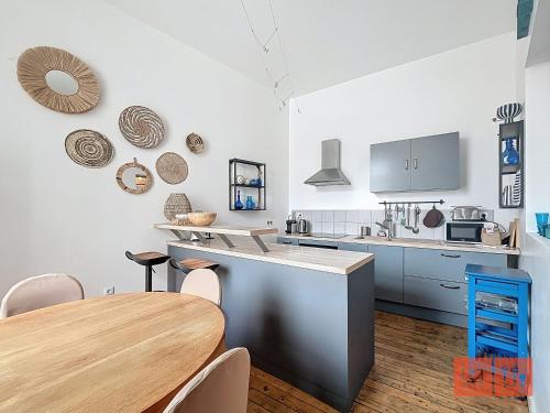 une cuisine avec une table en bois et une salle à manger dans l'établissement La parenthèse, à Wimereux