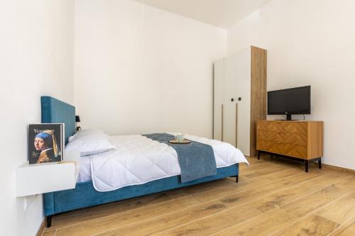 a bedroom with a bed and a television in it at Royal Loft - A due passi dal Centro Storico in Monza