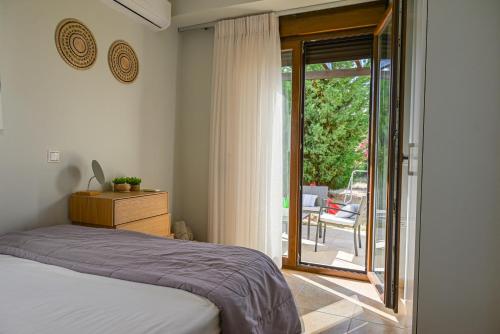 ein Schlafzimmer mit einem Bett und einer Glasschiebetür in der Unterkunft Villa Sunrise by the Sea in Kiotari
