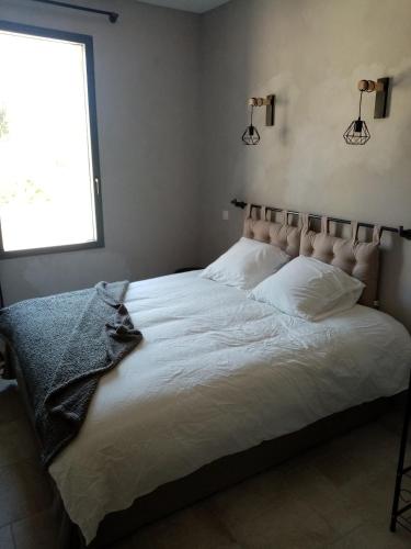 une chambre avec un grand lit blanc avec une fenêtre dans l'établissement Le passage 2, à Montaren-et-Saint-Médiers