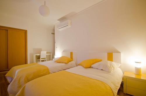 1 dormitorio con 2 camas con almohadas amarillas en Casa da Ladeira, Turismo Rural en Estreito
