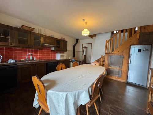 une cuisine avec une table avec des chaises et un réfrigérateur dans l'établissement GITE CHATELARD Magnifique gîte - Bourg St Maurice 8pers, à Bourg-Saint-Maurice