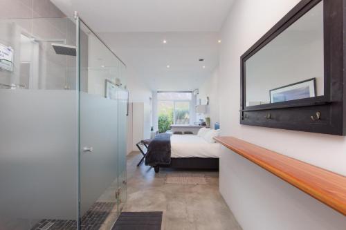 a bedroom with a bed and a mirror on the wall at The beachclub 17 in Hout Bay