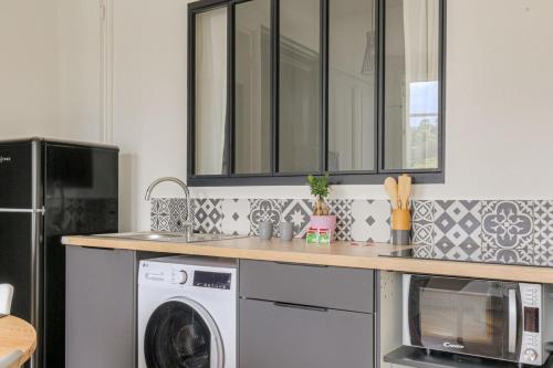une cuisine avec un lave-linge et un sèche-linge sur un comptoir dans l'établissement Charme et Caractère 10 min Bellecour, à Lyon