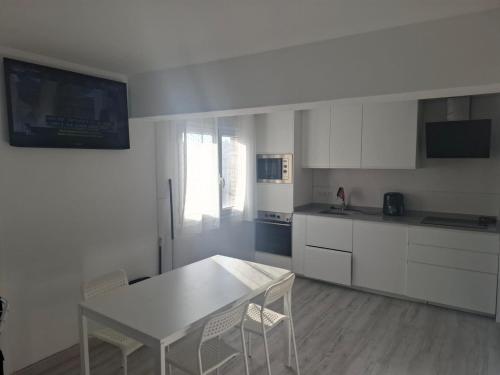 a kitchen with white cabinets and a table and chairs at Casa Sarmiento in Burgos