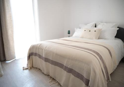 - une chambre avec un grand lit blanc et des oreillers blancs dans l'établissement Lou Cabanot - Appartement lumineux 3 chambres - Parking Gratuit, à Béziers