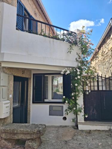 a house with a balcony and a bench in front of it at Casa rústica com terraço e jardim in Águas