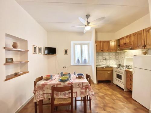 a kitchen with a table with chairs and a white refrigerator at In centro da Isabella in Sperlonga