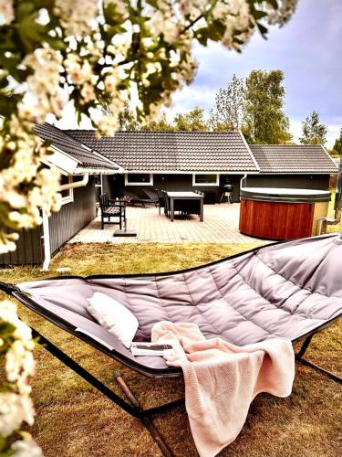 a hammock in a yard in front of a house at Cozy holiday home - spa, hot tub and play room - close to Marielyst square in Bøtø By