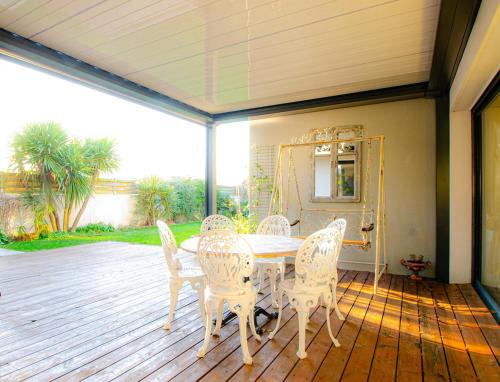 un patio avec une table et des chaises sur une terrasse dans l'établissement Villa neuve tout confort SHABBY CHIC, à Talmont-Saint-Hilaire