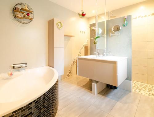 ein Badezimmer mit Badewanne und Waschbecken in der Unterkunft Villa neuve tout confort SHABBY CHIC in Talmont