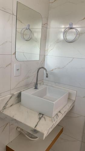 a bathroom with a white sink and a mirror at Pousada Vila das Grutas in João Pessoa