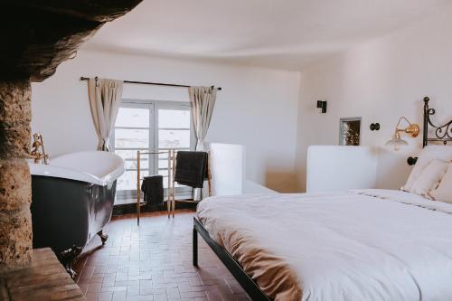 une chambre avec un lit, une baignoire et une fenêtre dans l'établissement Unique historical home, middle of the village, bath & patio, à Tourtour
