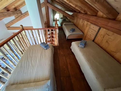 an attic room with two beds and a staircase at Mountain Chalet Splazoi in Strembo