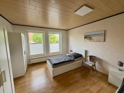 a bedroom with a bed and two windows at Monteurs- und Ferienwohnung Kahmen in Ahaus