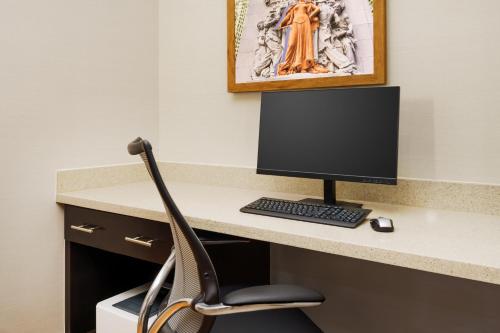 a desk with a computer monitor and a chair at Hampton Inn Chicago-Midway Airport in Chicago