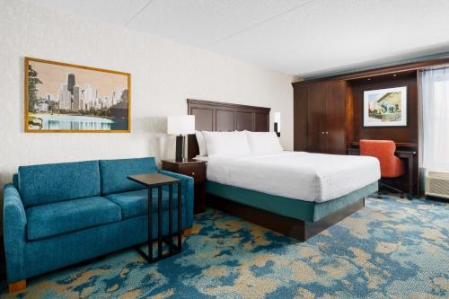 a hotel room with a bed and a couch at Hampton Inn Chicago-Midway Airport in Chicago