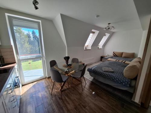 a bedroom with a bed and a table and chairs at Levendula Apartman Bükkszentkereszt in Bükkszentkereszt