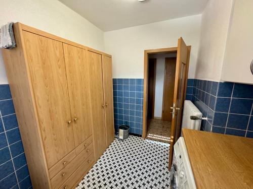 a bathroom with a door and a tiled floor at Monteurs- und Ferienwohnung Kahmen in Ahaus