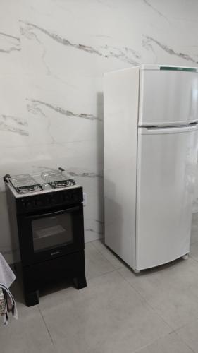 a kitchen with a stove and a refrigerator at Apartamento 4 completo centro in Sorriso