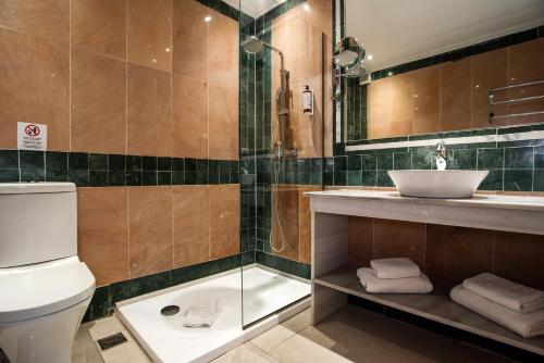 a bathroom with a toilet and a sink at Cavomarina Beach- Adults Only in Kavos