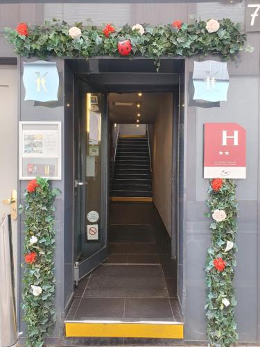une entrée d'un bâtiment avec une arche fleurie avec des fleurs dans l'établissement EtC...Hôtel - Strasbourg Hyper Centre, à Strasbourg