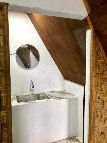 a bathroom with a sink and a mirror at Eger Rise Terrace Bungalow in Kotaraja