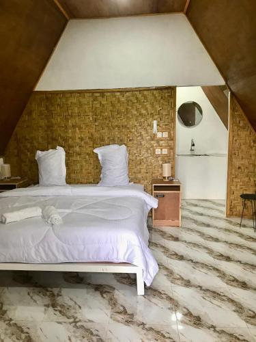 a bedroom with a large bed and a brick wall at Eger Rise Terrace Bungalow in Kotaraja