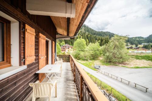 a balcony with a table and chairs and a view at La Flèche d'Or in Châtel