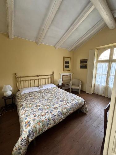 a bedroom with a bed with a floral bedspread at Villa Favorita in Bra